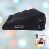 The SS Pivot Inflatable Positioner Plus by Sportsheets, featuring a black wedge shape with handles, is highlighted against a blurred backdrop of vibrant lights, perfect for enhancing intimate moments. In the corner, a boxed package displays the same product.